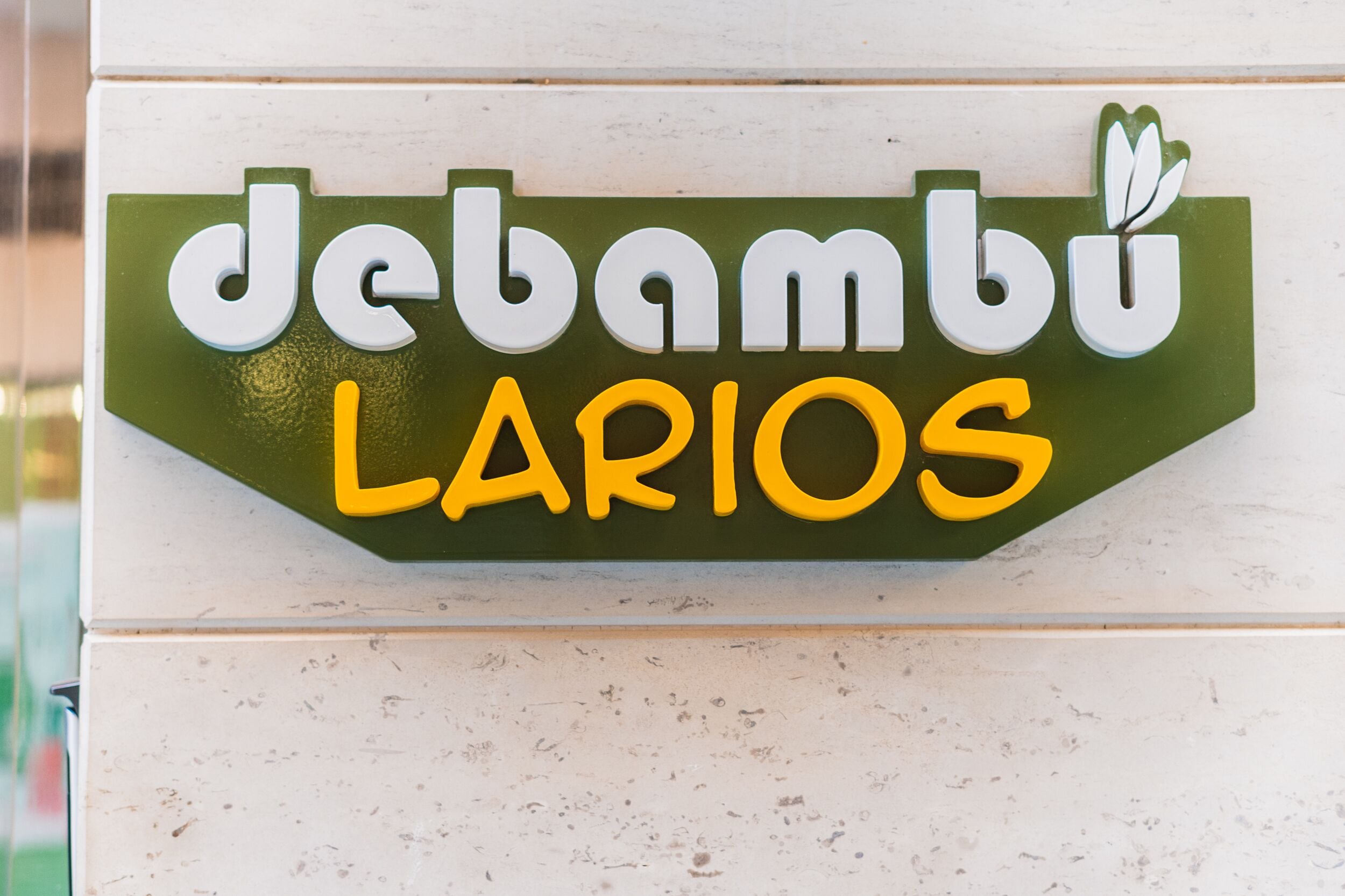 Una señal con el texto 'debambu LARIOS' sobre un fondo verde.