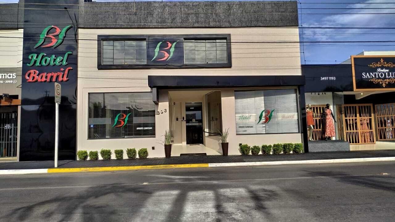 A hotel named 'Hotel Barril' with a modern facade, large windows, and a visible entrance.