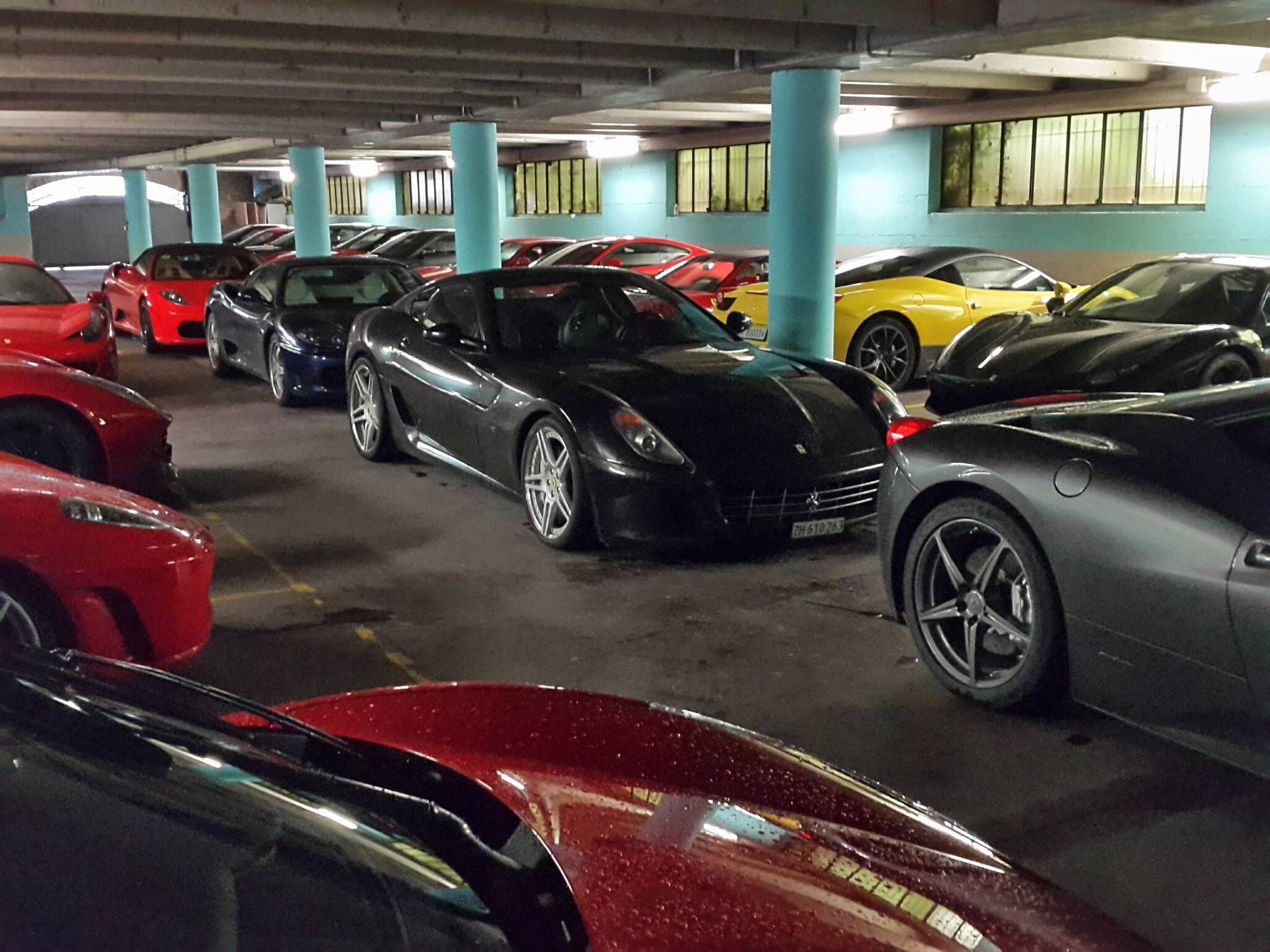 A parking garage with multiple cars parked in rows.