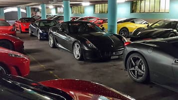 A parking garage with multiple cars parked in rows.