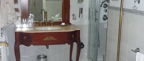 Une salle de bain avec un meuble-lavabo en bois, un grand miroir, des toilettes et un espace douche.