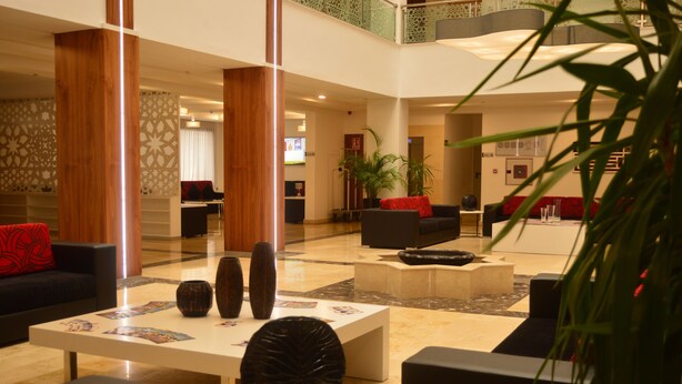A spacious lobby with a high ceiling, a central coffee table, sofas, and a staircase. - Prestige Hotel (Tetouan)