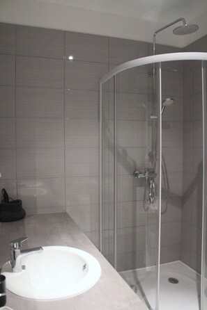 Deluxe tweepersoonskamer | Badkamer | Een douche, gratis toiletartikelen, een haardroger, pantoffels