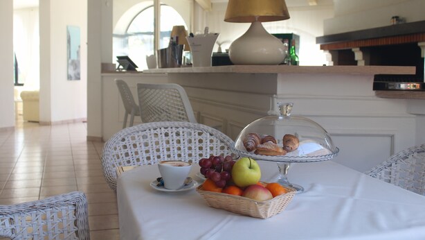 A breakfast setting with a table, chairs, a lamp, and a fruit basket. - Hotel La Settima Luna (Umag)