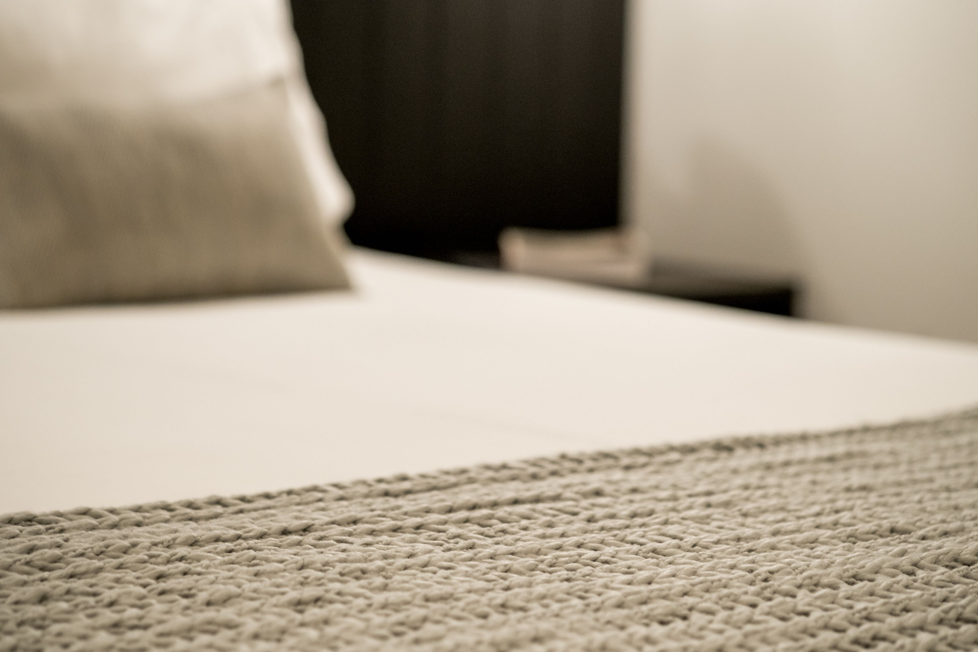 Un gros plan d’un tapis beige à texture et à motifs tissés, qui fait partie du revêtement de sol d’une pièce.