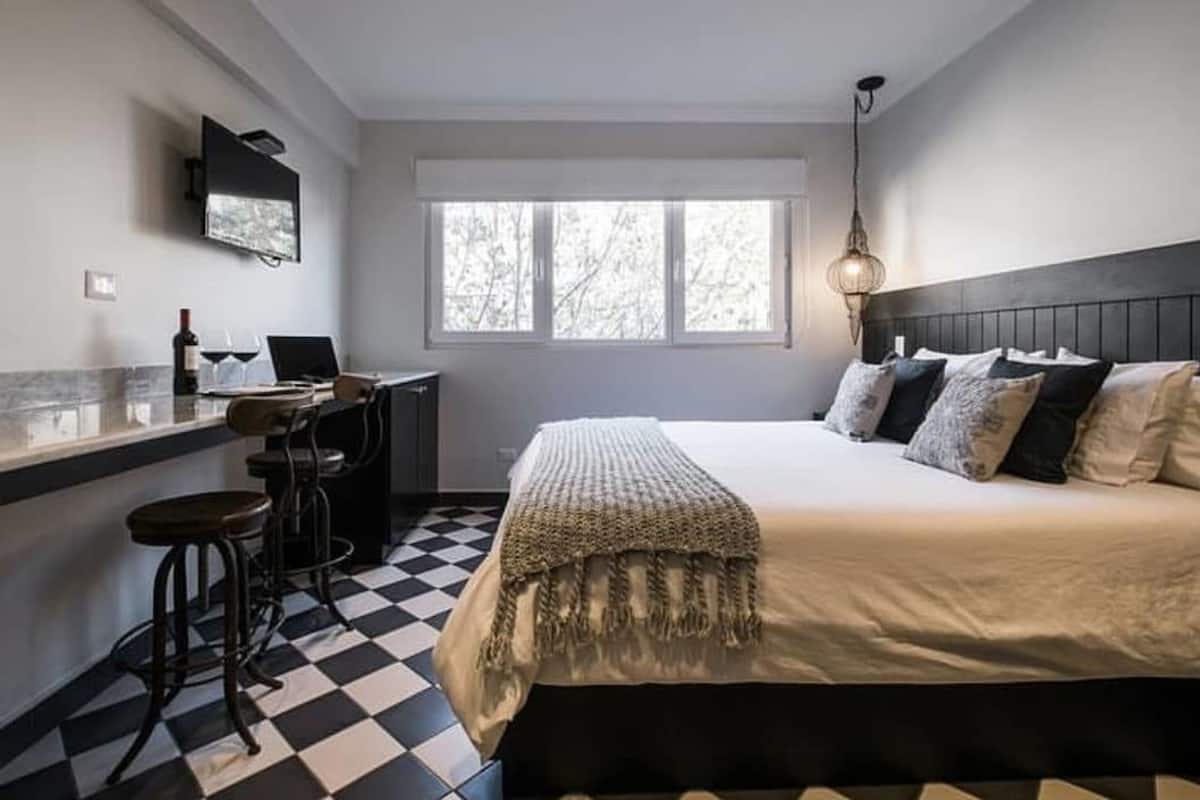 A bedroom with a bed, a desk, and a chair.