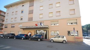 A multi-story hotel with a beige facade, named "Hotel Moderno," featuring a central entrance with a glass door and a visible flag. - Hotel Moderno (Pontassieve)