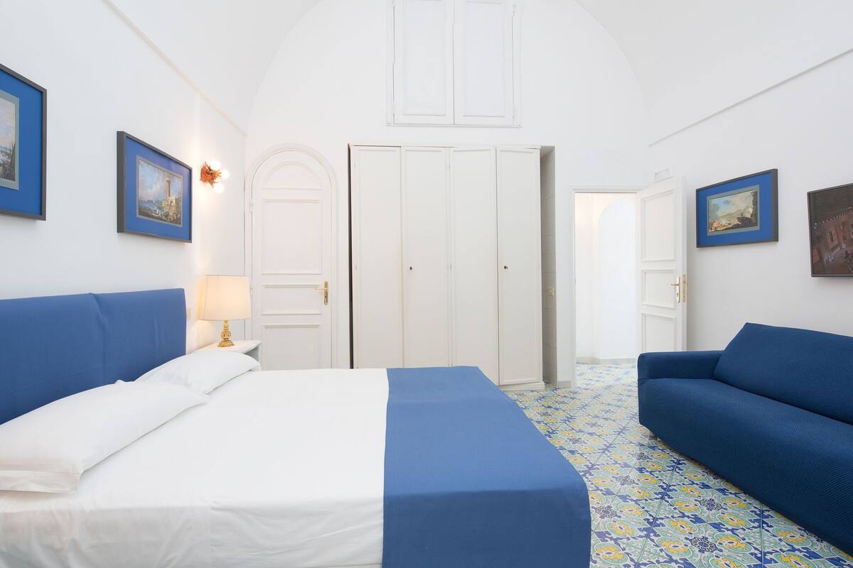 Una habitación de hotel con una cama, un sofá y un televisor.