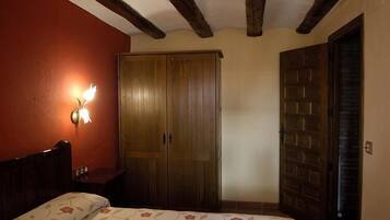 Un dormitorio con cama, un armario de madera y una lámpara de pared.
