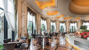 A spacious dining area with multiple tables and chairs, large windows, and a central bar area.