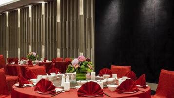 A dining area with round tables, red chairs, and a modern interior design.