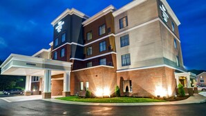 Un hotel de varios pisos con fachada de ladrillo y un acceso cubierto.