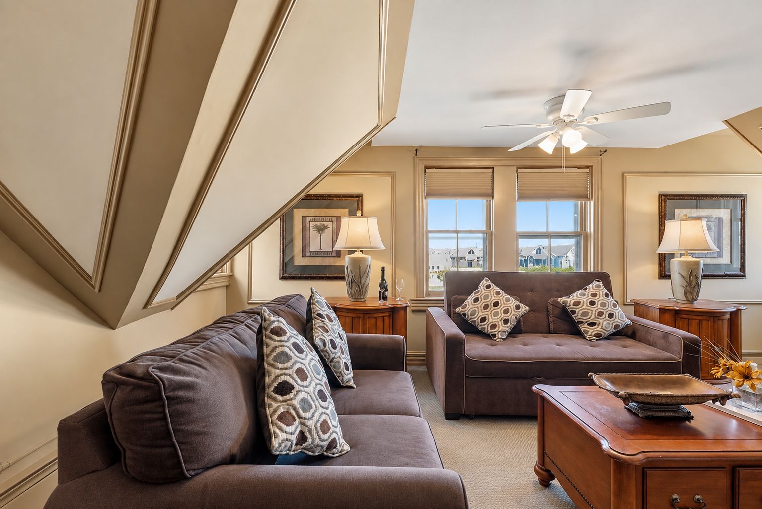 A living room with two sofas, a coffee table, and a ceiling fan.