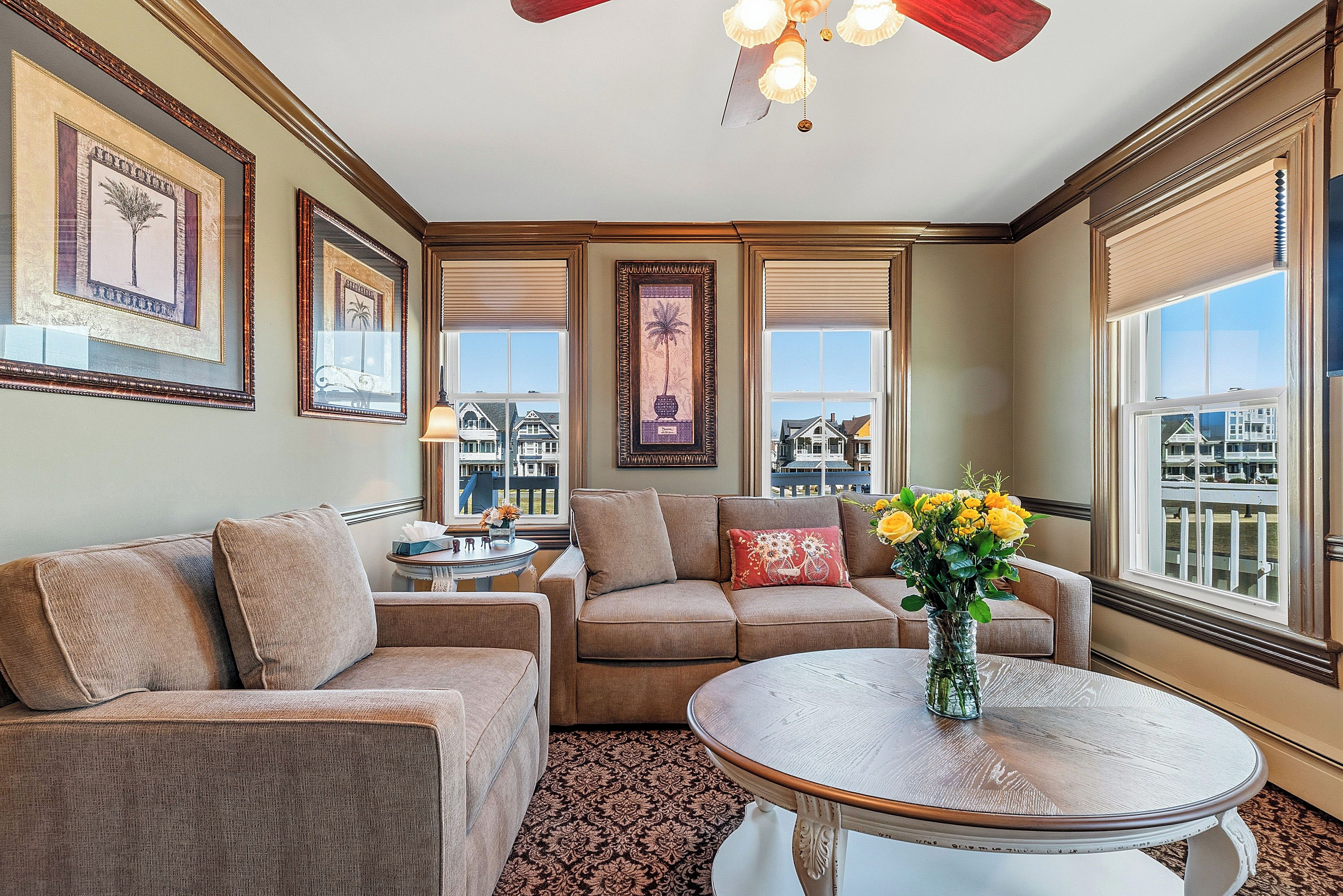 A well-appointed living room with a sofa set, a coffee table, and a view of the cityscape through large windows.