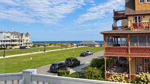 A coastal property with a two-story building, a covered outdoor seating area, and a view of the ocean. - Ocean View Inn (Ocean Grove)