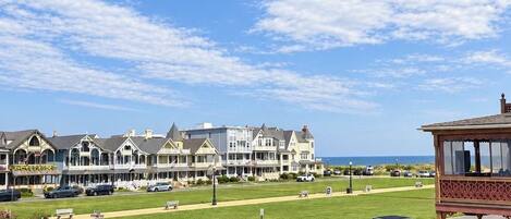 A coastal hotel with a lawn and a view of the ocean.