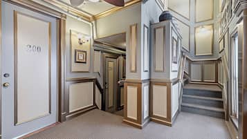 A hallway with doors numbered 200 and 201, carpeted floors, and a staircase.