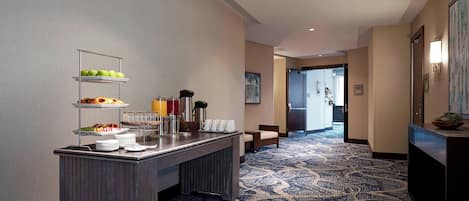 Eine Hotelhalle mit einem Buffet, einem gemusterten Teppich und einem Empfangsbereich.