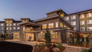 A modern hotel with multiple floors, large windows, and a well-lit entrance. - Residence Inn by Marriott Portland Hillsboro/Brookwood (Hillsboro)