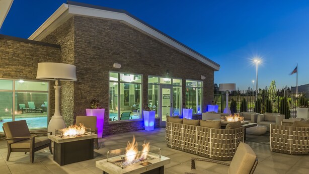 An outdoor patio with fire pits, seating, and a pool view. - Residence Inn by Marriott Portland Hillsboro/Brookwood (Hillsboro)