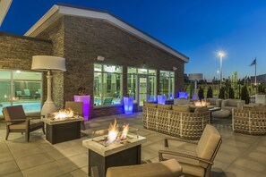 An outdoor patio with fire pits, seating, and a pool view. - Residence Inn by Marriott Portland Hillsboro/Brookwood (Hillsboro)