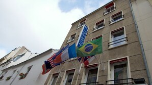 A building with multiple flags, including the Brazilian flag, and a sign reading "AUBERGE INTERNATIONALE DES JEUNES". - Auberge Internationale des Jeunes (Paris)