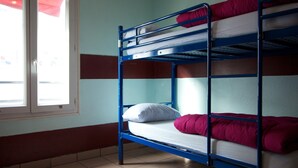 A bunk bed room with a window, white pillow, and red blanket. - Auberge Internationale des Jeunes (Paris)