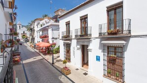 A narrow street lined with white buildings, some with balconies and potted plants. - Hotel La Morada Mas Hermosa (Marbella)