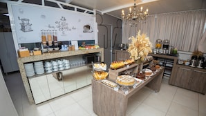 A breakfast buffet with various food items and a coffee station. - Concept Hotel Flat  (Balneário Camboriú)
