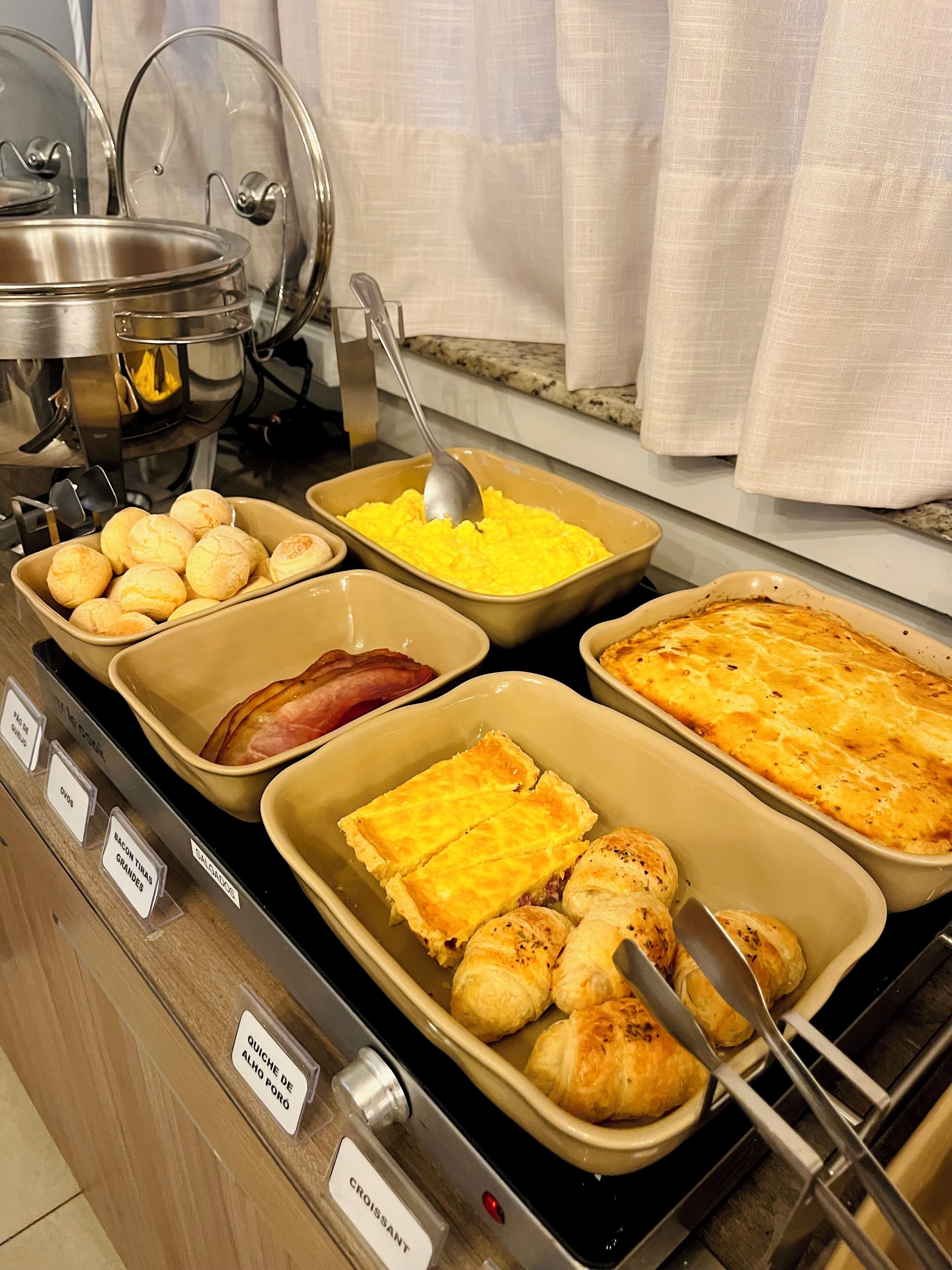 A buffet with various food items including quiche de l'oeuf porpoise, croissants, and other baked goods.