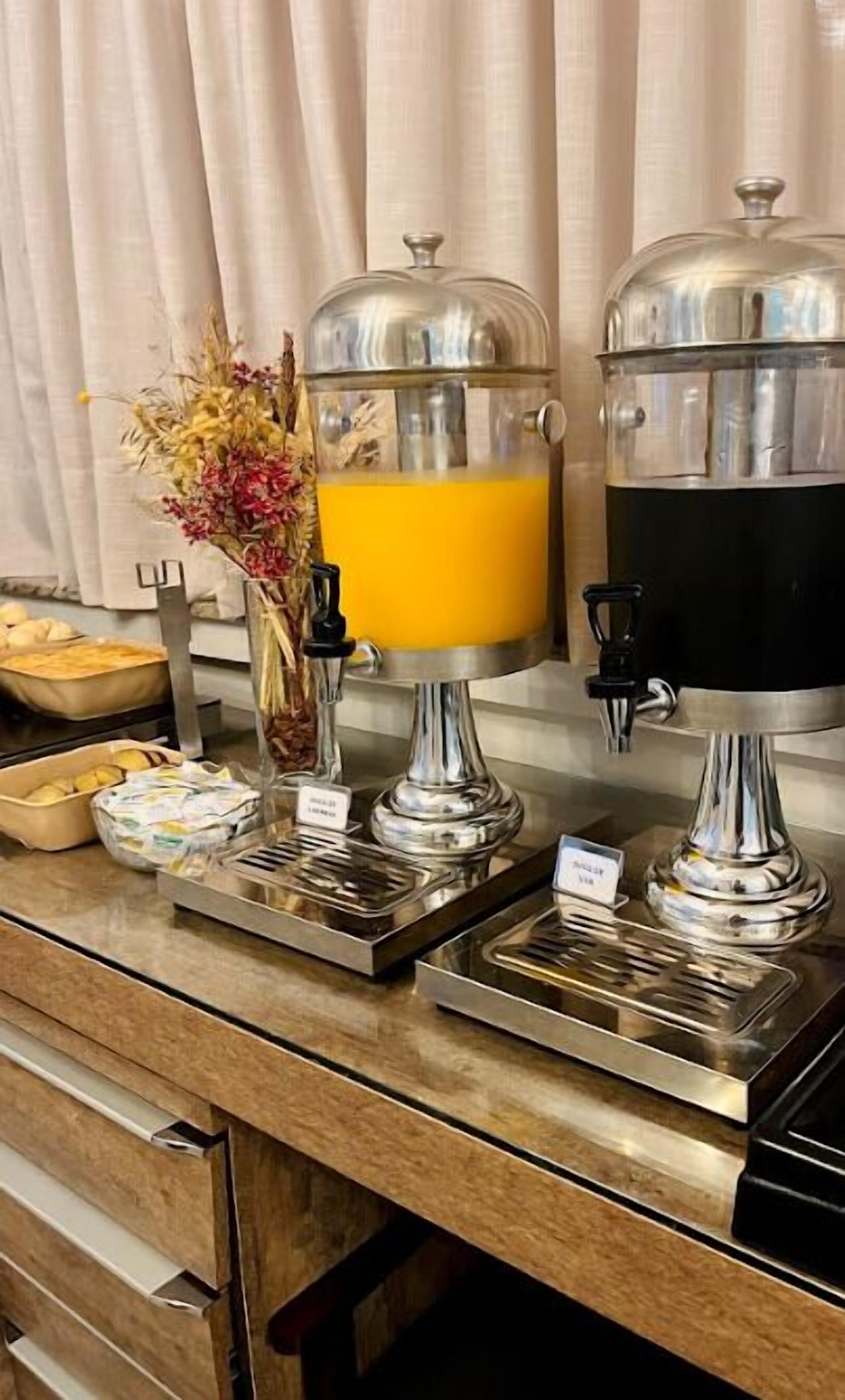 A buffet setup with various food items and a beverage dispenser.