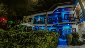 A two-story building with a balcony on the upper floor, surrounded by greenery. - Pousada Larissa (Paraty)