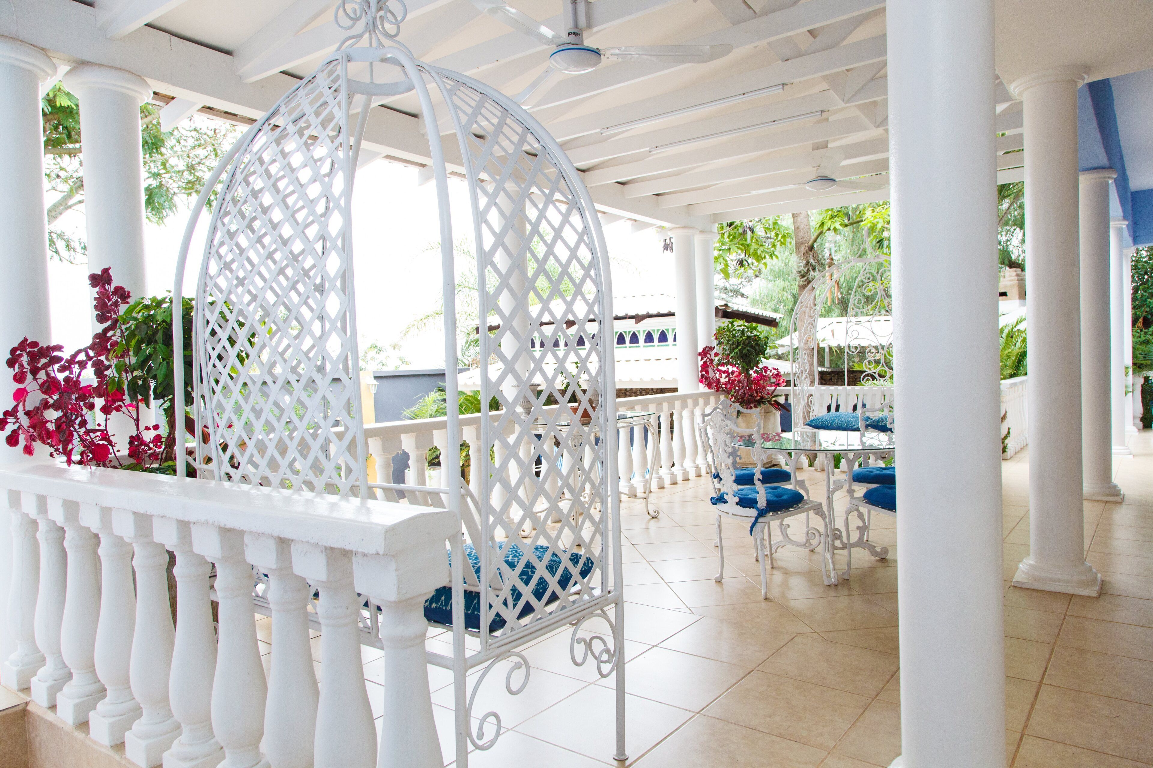 A covered outdoor area with white columns and a white lattice structure.