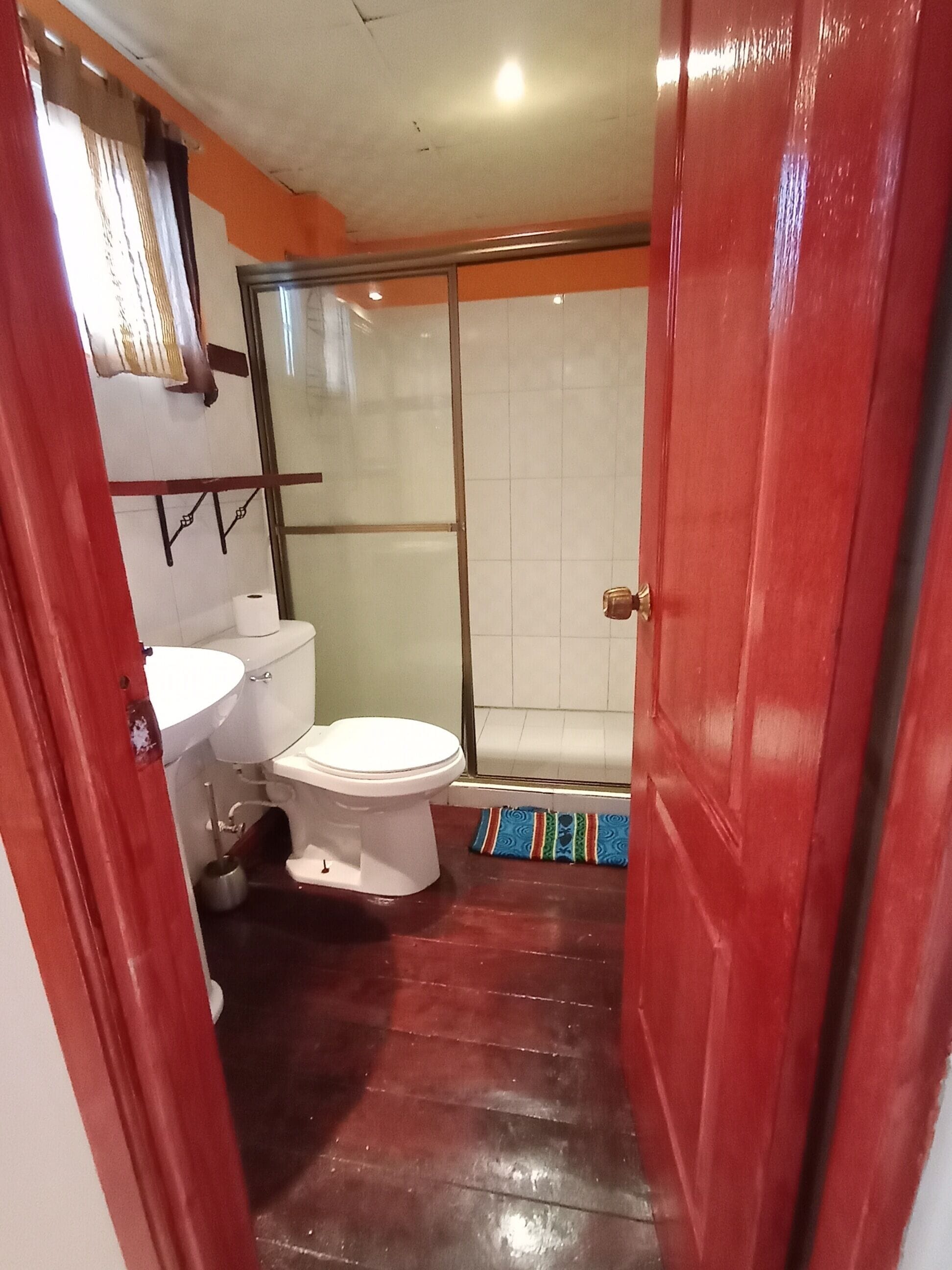 A bathroom with a toilet, sink, and shower area.