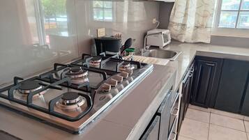 Apartamento estándar, balcón, en una planta alta | Cocina privada | Frigorífico grande, licuadora, utensilios de cocina y mesa de comedor