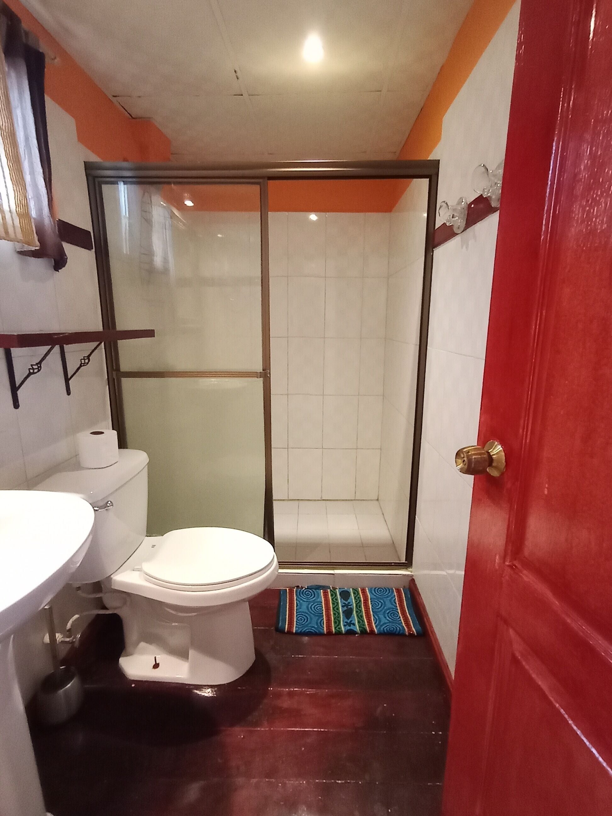 A bathroom with a toilet, sink, and shower area.