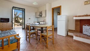 A compact living space with a dining area, kitchen, and a fireplace. - Casa Frulli (Uggiano la Chiesa)