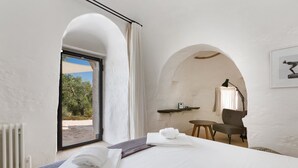 A hotel room with a bed, a window, a chair, and a table.