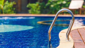 Una piscina al aire libre, tumbonas