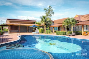Una piscina al aire libre, sillones reclinables de piscina