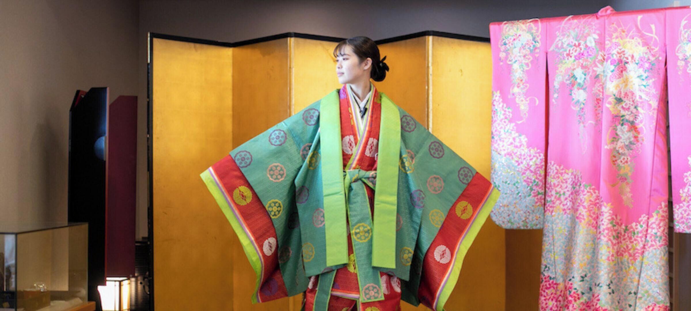 Ein traditioneller japanischer Raum mit Tatami-Boden, einem Shoji-Bildschirm und einem farbenfrohen Kimono an der Wand.