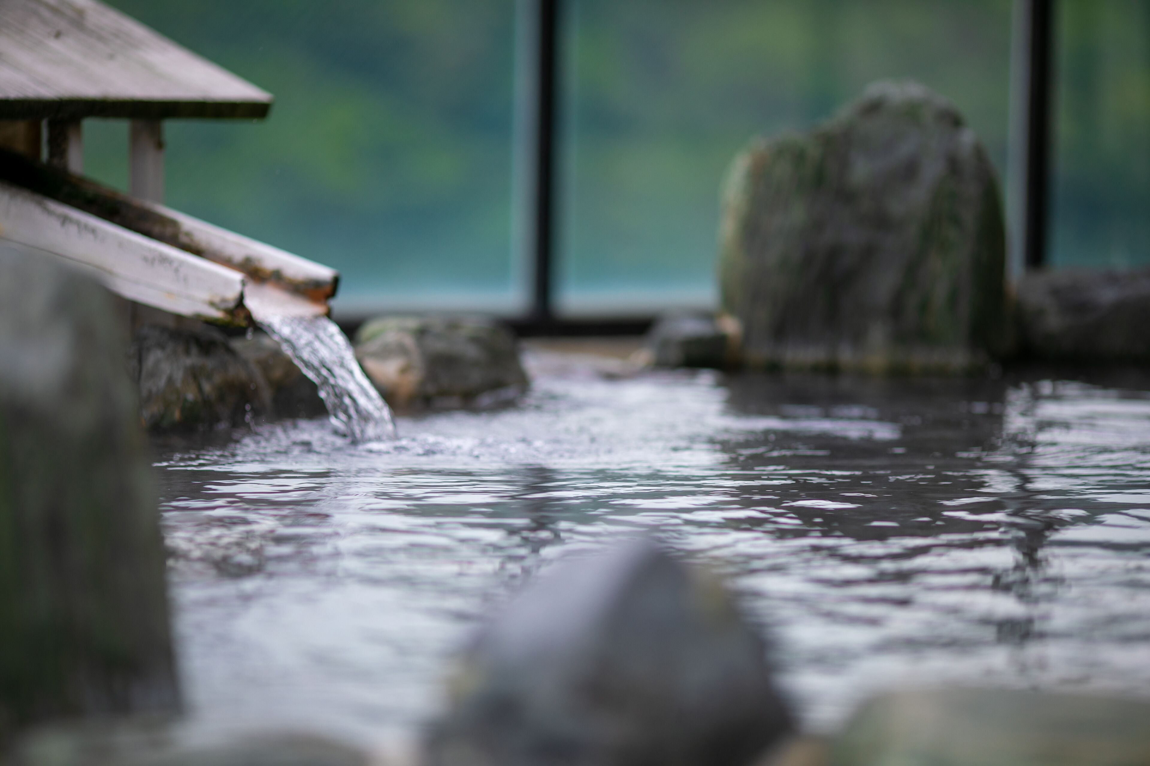A water feature with a wooden structure and rocks.