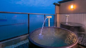 Un jacuzzi con agua en movimiento, una terraza de madera y vista al océano.