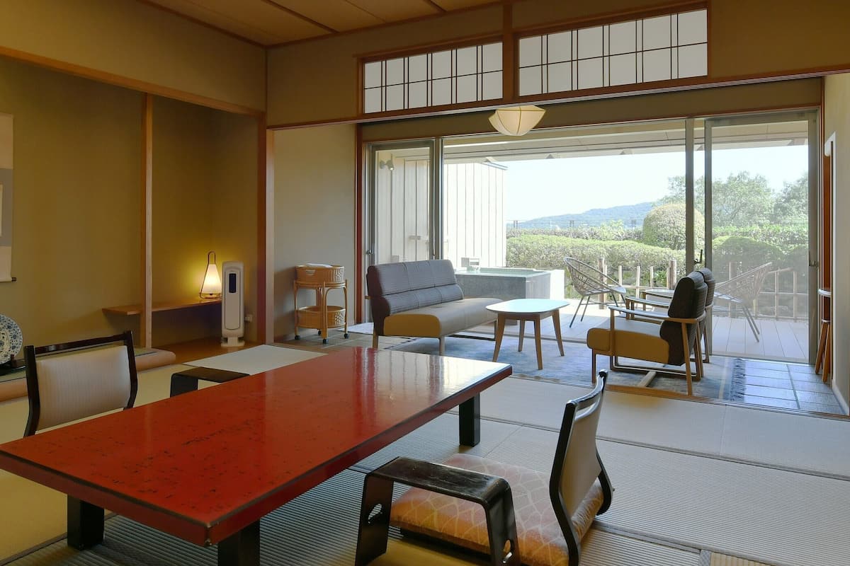 A traditional Japanese-style room with tatami flooring, a low table, and a sofa.
