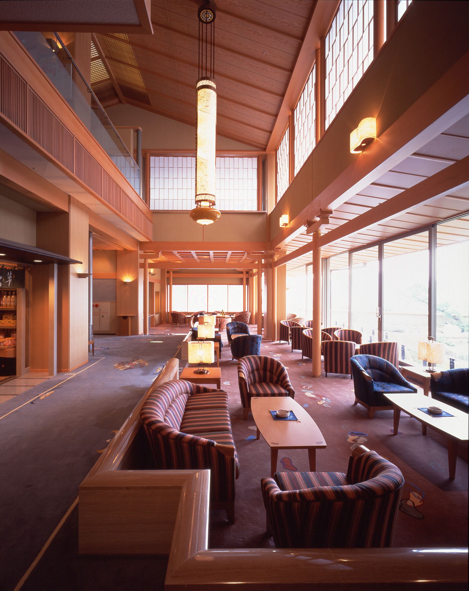 A spacious lobby with high ceilings, large windows, and a variety of seating options including sofas and armchairs.