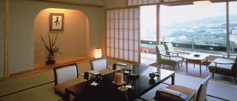 A traditional Japanese-style room with tatami flooring, a low table with cushions, and sliding shoji doors.