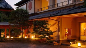 A traditional Japanese building with a wooden exterior, a tiled roof, and a well-lit entrance. - Seizan Yamato (Ito)