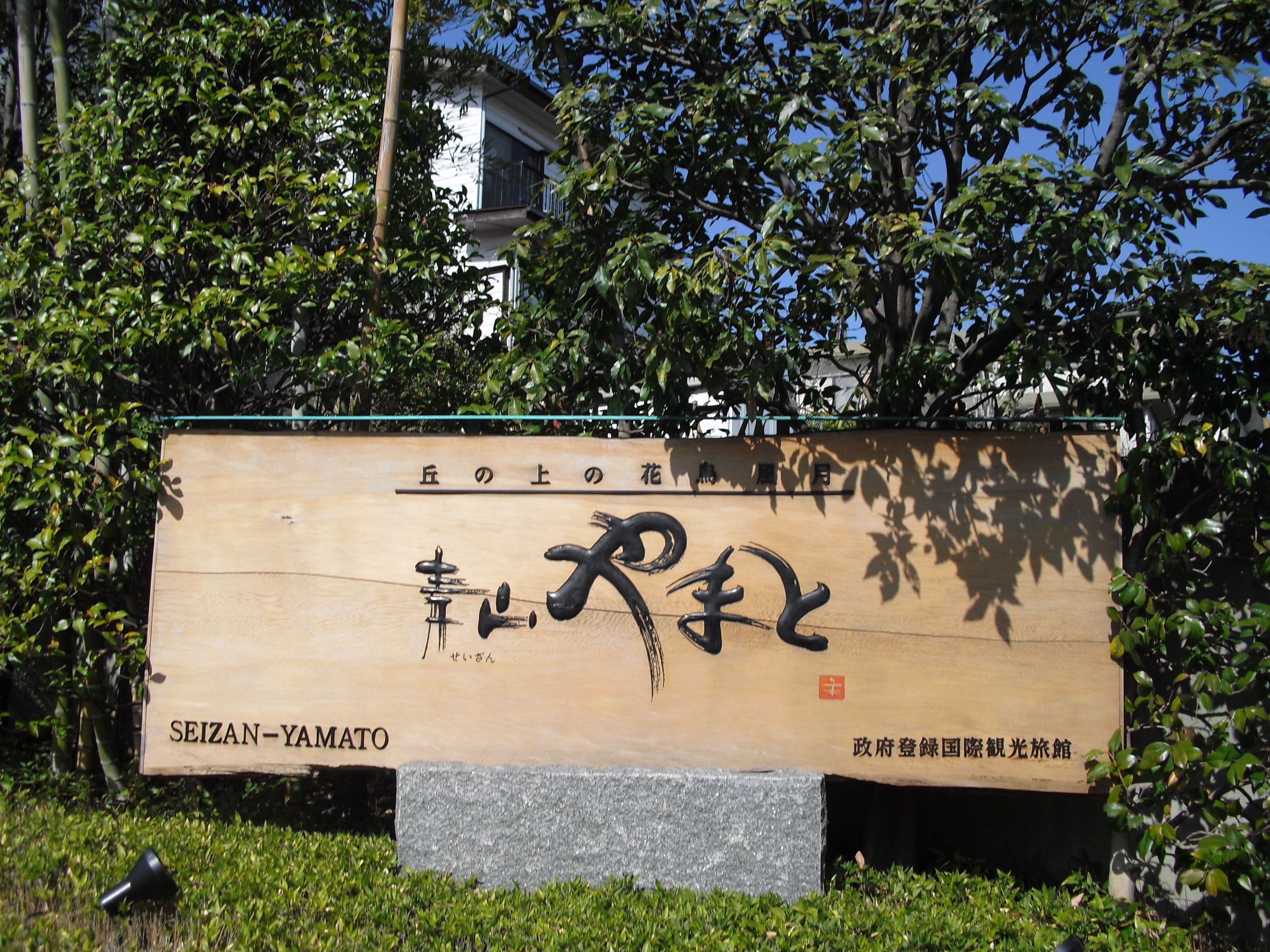 A wooden sign with Japanese characters and the name "SEIZAN-YAMATO" at the bottom.