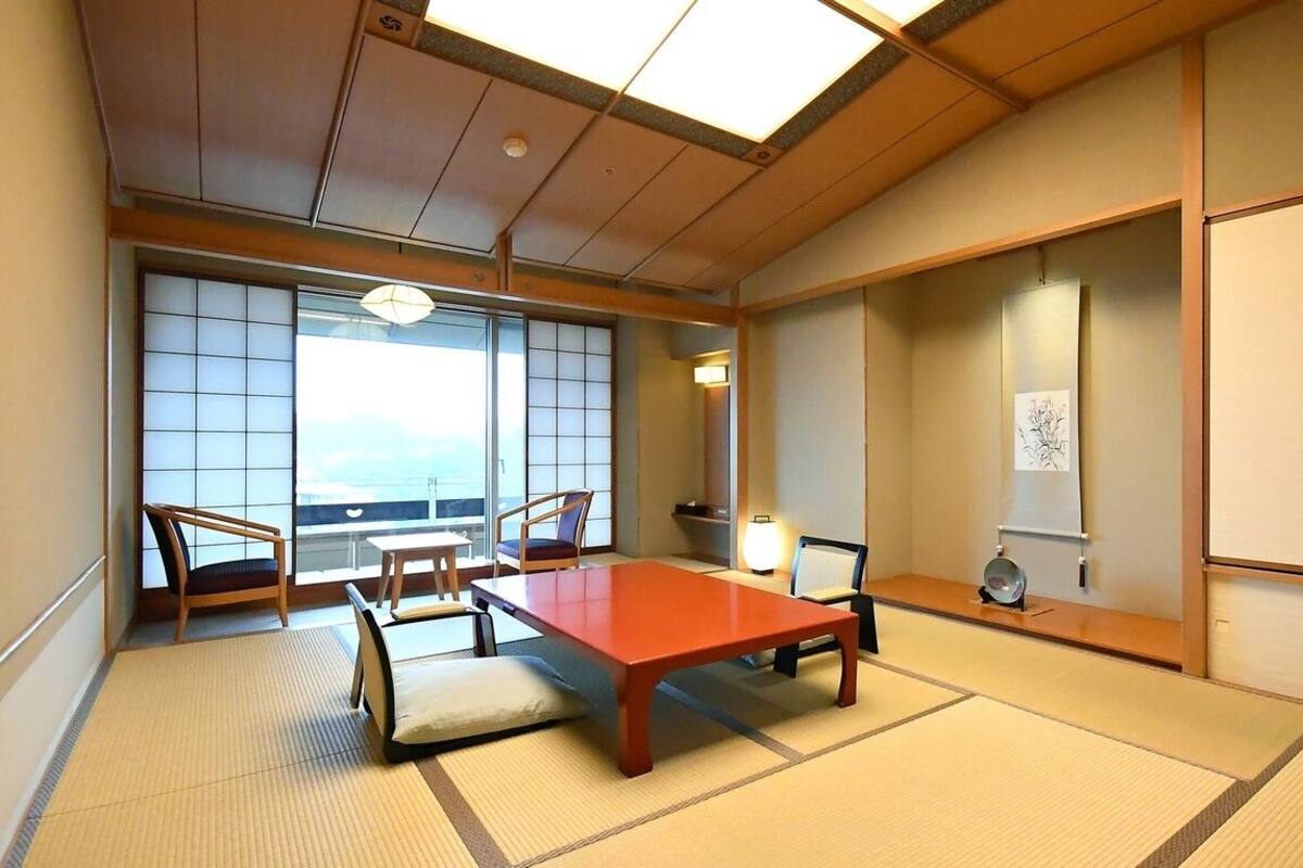 A traditional Japanese room with tatami flooring, a low table, and sliding doors.