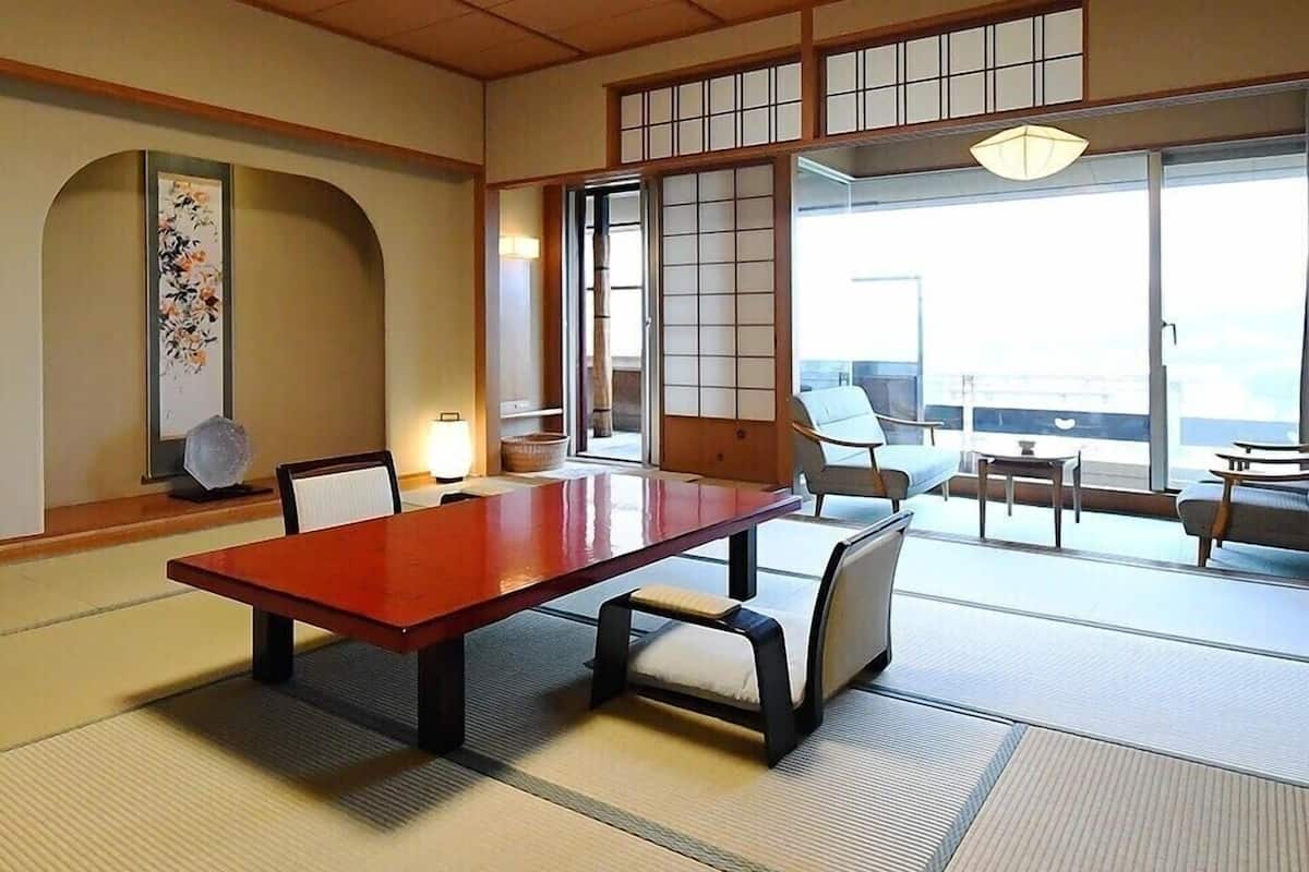 A traditional Japanese-style room with tatami flooring, a low table, and sliding doors.